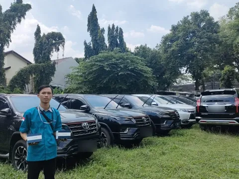 Teknisi gpssupertrack berseragam di depan deretan mobil pribadi